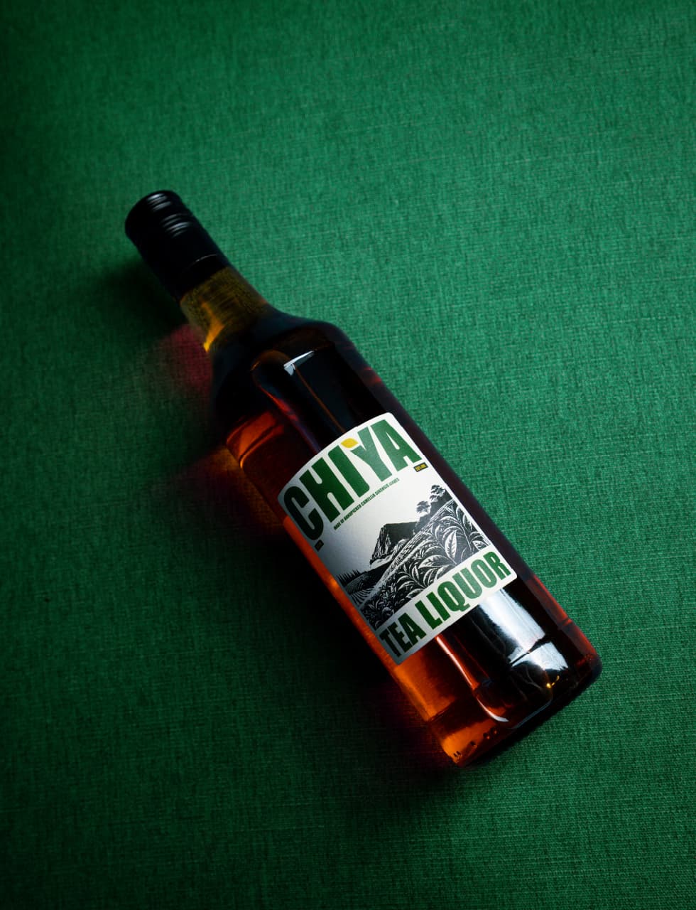 Chiya tea liquor bottle lit warmly against a dark background